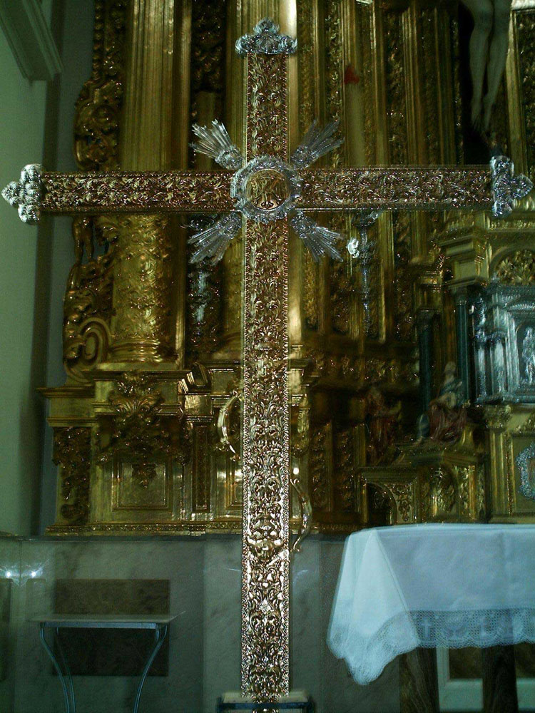 IMAGEN DEL LA CRUZ DE GUIA DE LA HERMANDAD Y DETRAS EL HERMOSO RETABLO DE LAS OBRERAS